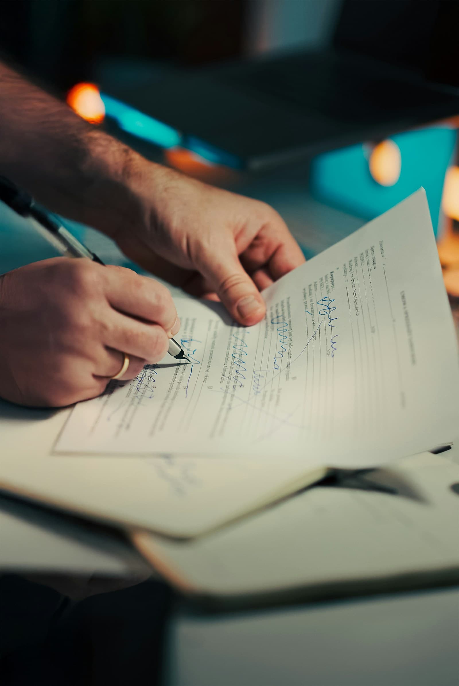 A person signing and reviewing a printed business document