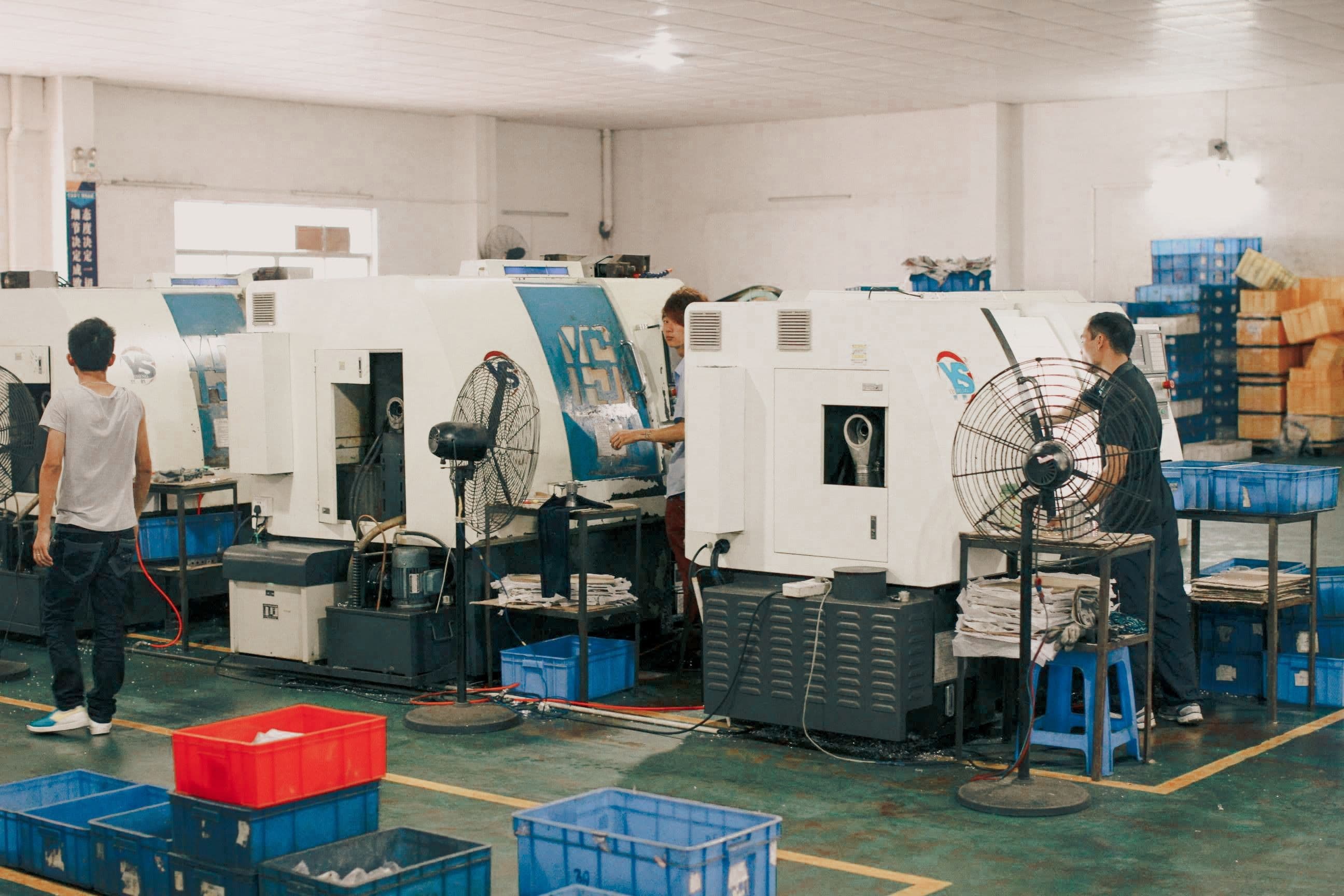 Workers operating machinery on an industrial factory floor
